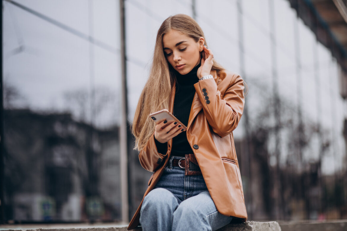 Young woman in jacket walking out in the city